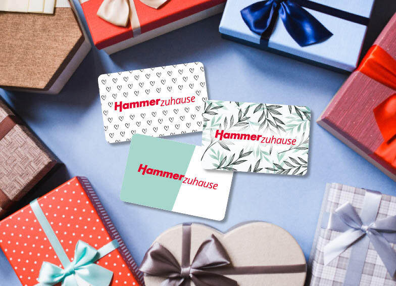 Drei Designs der Hammer GeschenkCard mit bunten Geschenkboxen drum herum, was auf die Möglichkeit hinweist, einen Hammer Gutschein zu kaufen.